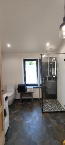 a bathroom with a glass shower with a table and a window at Beach old fisherman's house in Jūrmala