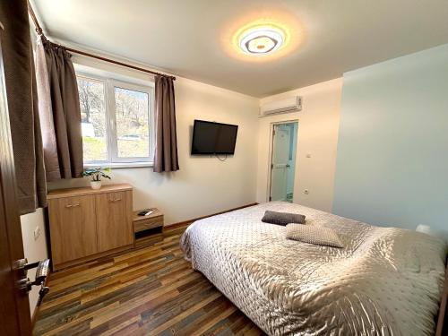 a bedroom with a bed and a flat screen tv at Navial in Gabrovo