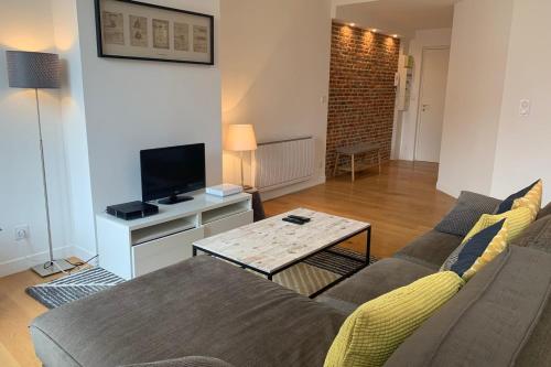 un salon avec un canapé et une table dans l'établissement Lille centre - Beautiful bright apartment!, à Lille
