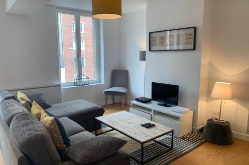 un salon avec un canapé et une télévision dans l'établissement Lille centre - Beautiful bright apartment!, à Lille
