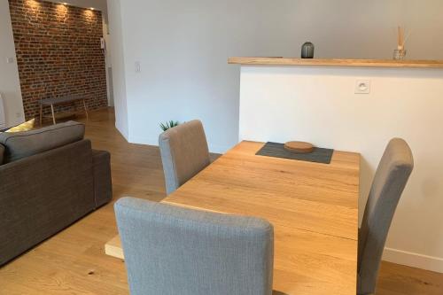 un salon avec une table et des chaises en bois dans l'établissement Lille centre - Beautiful bright apartment!, à Lille