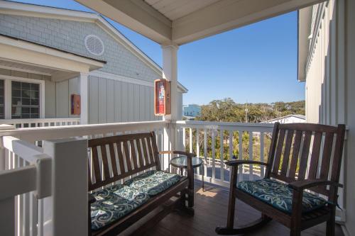 a porch with two rocking chairs on a balcony at Retreat 5B - Edisto Blessing in Edisto Island