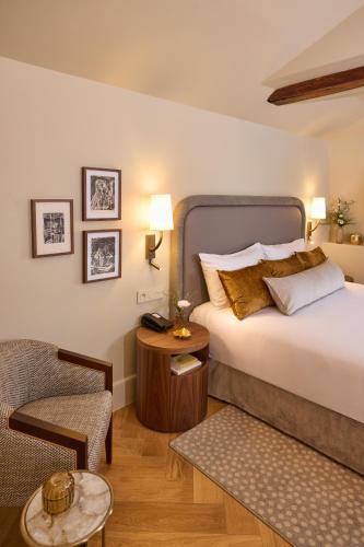 a hotel room with a bed and a chair at Maison 1896 in Beaune