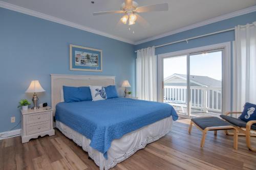 een blauwe slaapkamer met een bed en een balkon bij Retreat 5B - Edisto Blessing in Edisto Island