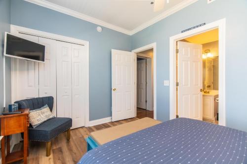 a bedroom with blue walls and a bed and a chair at Retreat 5B - Edisto Blessing in Edisto Island