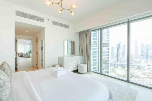 ein Schlafzimmer mit einem großen weißen Bett und einem großen Fenster in der Unterkunft Downtown Views II Burj Khalifa View, Downtown Dubai - Mint Stay in Dubai