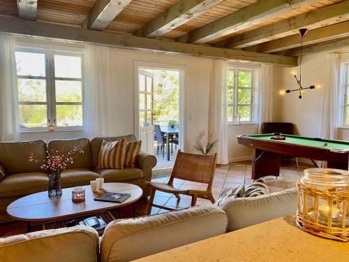 a living room with couches and a pool table at Fantastic Spa-house Surrounded By Nature in Udsholt Sand
