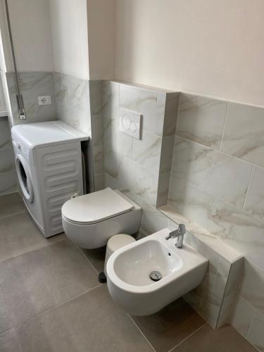 a white bathroom with a toilet and a sink at COZY LAKE COMO APARTMENTS in Valmadrera
