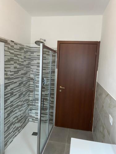 a shower with a wooden door in a bathroom at COZY LAKE COMO APARTMENTS in Valmadrera