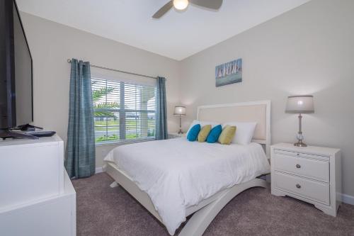 una camera bianca con un letto e una finestra di 4933IG TOWNHOUSE 4 BED/3 BATHS (SANITIZED) a Kissimmee