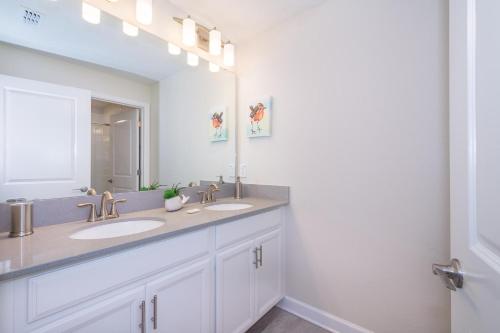 un bagno con due lavandini e un grande specchio di 4933IG TOWNHOUSE 4 BED/3 BATHS (SANITIZED) a Kissimmee