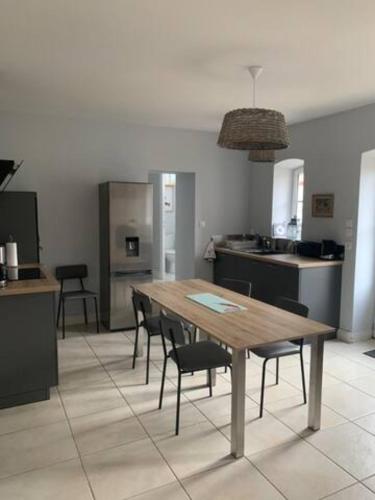 Il comprend une cuisine avec une table et des chaises en bois. dans l'établissement Domaine de la Garnauderie Gite des Chênes, à Sainte-Maure-de-Touraine