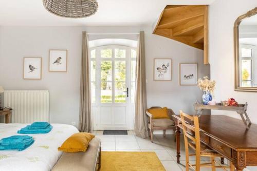 une chambre avec un lit, un bureau et une table dans l'établissement Domaine de la Garnauderie Gite des Chênes, à Sainte-Maure-de-Touraine