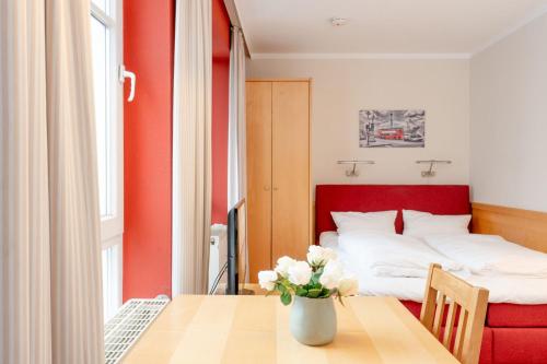 um quarto com uma cama e uma mesa com um vaso de flores em Fewo 601, Seepark Sellin em Ostseebad Sellin