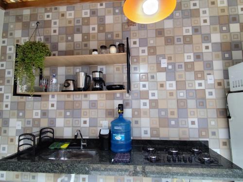 a bottle of water is sitting on a kitchen counter at Loft 61 - No coração de Curvelo in Curvelo