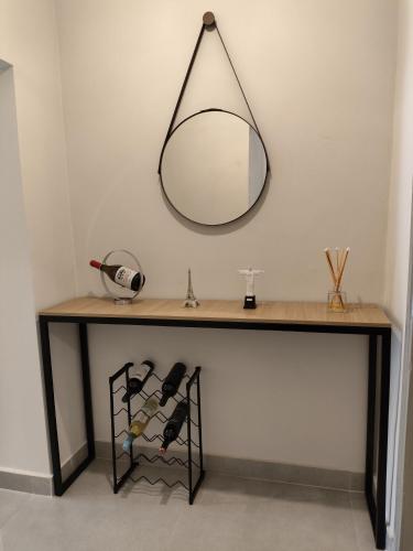 a table with a mirror and some wine bottles at Loft 61 - No coração de Curvelo in Curvelo
