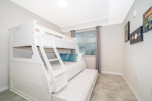 ein weißes Etagenbett in einem Zimmer mit Fenster in der Unterkunft 3120-202IG STOREY LAKE, CONDO 2/2 GARDEN VIEW in Kissimmee