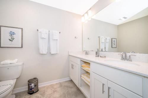 ein weißes Bad mit einem Waschbecken und einem WC in der Unterkunft 3120-202IG STOREY LAKE, CONDO 2/2 GARDEN VIEW in Kissimmee