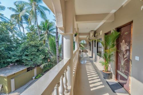 a balcony of a house with palm trees at Rosa Bella Resort-TBV in Calangute