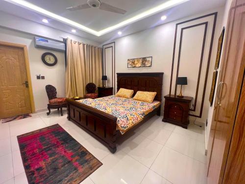 a bedroom with a bed and a table and chairs at Luxuriant 3 Bed Apartment Defence Residency DHA Phase 2 Islamabad The Realtors Inn in Islamabad