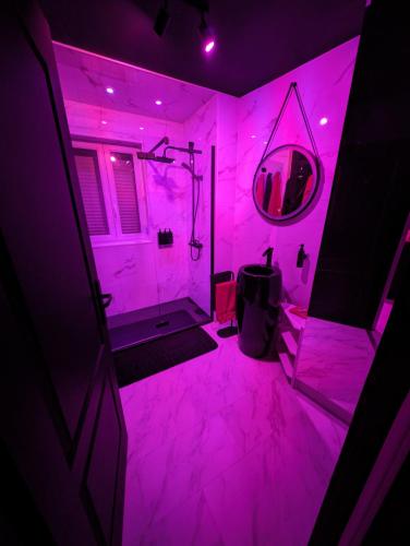 baño rosa con espejo y habitación rosa en Le Spacidulé, en Saint-Amand-les-Eaux