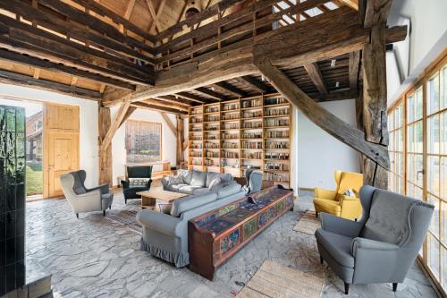 a living room filled with furniture and a large wall of books at Mesendorf Gasthaus in Meşendorf