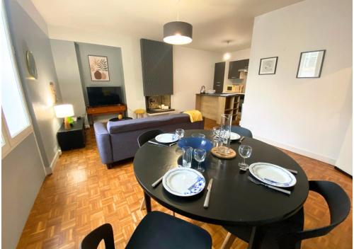 une table à manger et des chaises dans un salon dans l'établissement Le 107 - Poitiers - CHU - La Conciergerie., à Poitiers