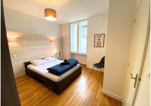 une chambre avec un lit sur lequel est allongé un chat dans l'établissement Le 107 - Poitiers - CHU - La Conciergerie., à Poitiers