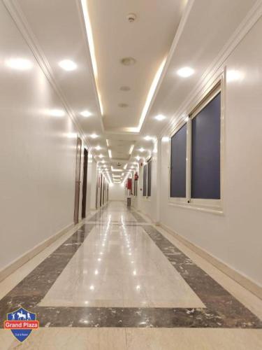 a long hallway with white walls and a long ceiling at Grand Plaza Hotel & Resort in Qaryat ash Shamālī
