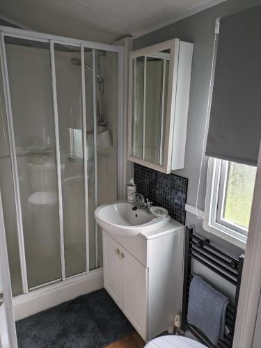 een badkamer met een witte wastafel en een douche bij Blues Hideaway Todber Valley in Gisburn