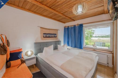 a bedroom with a large white bed and a window at Ferienanlage am Gothensee 25 Kreativhaus am See in Gothen