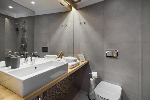 a bathroom with a white sink and a toilet at Mesendorf Gasthaus in Meşendorf