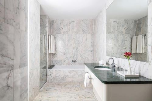 Baño blanco con lavabo y bañera en Anantara New York Palace Budapest - A Leading Hotel of the World en Budapest