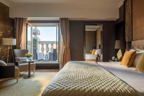 ein Schlafzimmer mit einem großen Bett und einem großen Fenster in der Unterkunft Anantara New York Palace Budapest - A Leading Hotel of the World in Budapest