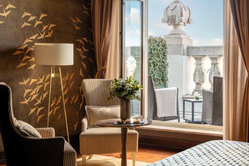 Pokój z krzesłami, stołem i oknem w obiekcie Anantara New York Palace Budapest - A Leading Hotel of the World w Budapeszcie