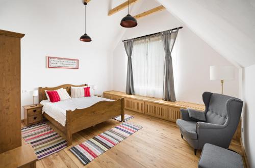 a bedroom with a bed and a chair at Mesendorf Gasthaus in Meşendorf