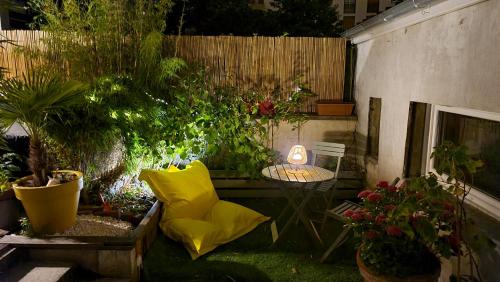 un jardin avec une table, des plantes et une clôture dans l'établissement Le studio dans le jardin., à Rosny-sous-Bois
