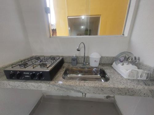 Il comprend une cuisine équipée d'une cuisinière et d'un évier. dans l'établissement Casa em Frente ao Mar, à Prado