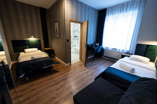 a hotel room with two beds and a window at Elegant Apartments in Poznań