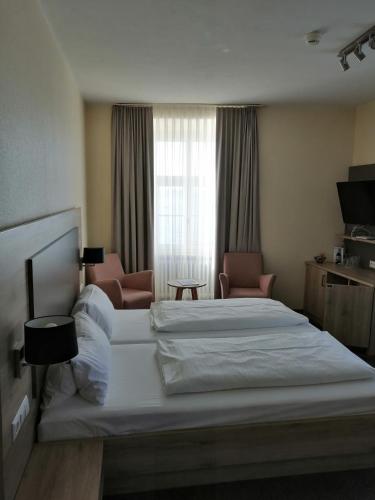 a hotel room with two beds and a window at Flair Hotel zum Schiff in Meersburg