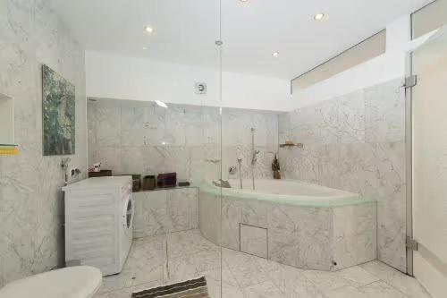 uma casa de banho com um chuveiro, uma banheira e um WC. em Apartment City Uniklinik em Friburgo em Brisgóvia