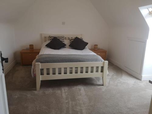 a bedroom with a bed with two night stands and two pillows at Spacious and warm 2 bedroom apartment sleeps up to 5 in Athy