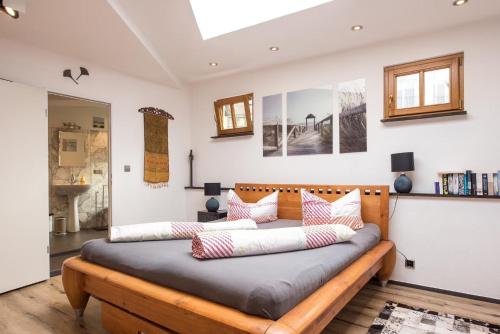 a bedroom with a wooden bed with pillows on it at Top City Apartment Uniklinik in Freiburg im Breisgau