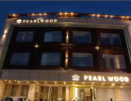 a building with a sign on the front of it at HOTEL PEARL WOOD (A unit of olive hospitality group) in Zirakpur