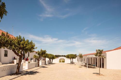 una calle en una ciudad con árboles y edificios en Casas da Quinta de Cima en Vila Nova de Cacela