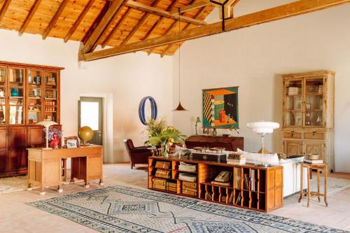 a living room with a table and a desk at Casas da Quinta de Cima in Vila Nova De Cacela