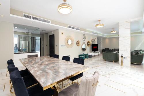 a dining room with a large marble table and chairs at Exclusive 6 Bedroom Villa with Pool and Gym access in Dubai