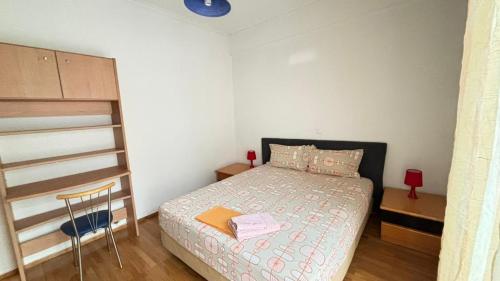 a small bedroom with a bed and a chair at Cozy home in Kypseli in Athens