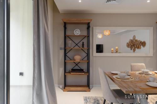 a dining room with a table and a shelf at Boho Inspired Large Luxury Villa in Dubai