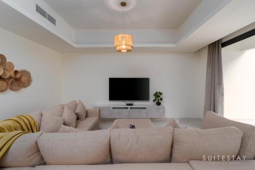 a living room with a couch and a flat screen tv at Boho Inspired Large Luxury Villa in Dubai
